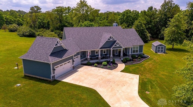 1015 Settlemyre Rd, Oregonia, OH 45054 - craftsman-style house featuring covered porch, a storage unit, a garage, and a front yard