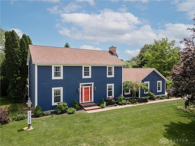 2025 Seneca Dr, Troy, OH 45373 - colonial house featuring a chimney, a front yard, and a shingled roof