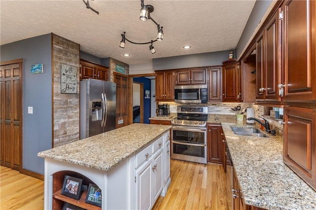 2025 Seneca Dr, Troy, OH 45373 - kitchen featuring appliances with stainless steel finishes, open shelves, a kitchen island, light wood-type flooring, and a textured ceiling