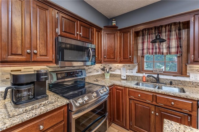 2025 Seneca Dr, Troy, OH 45373 - kitchen featuring stainless steel appliances, backsplash, light stone counters, a textured ceiling, and brown cabinetry