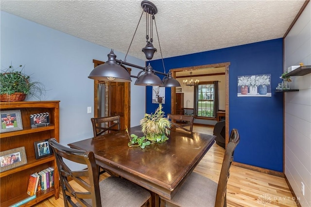 2025 Seneca Dr, Troy, OH 45373 - dining room featuring light wood-type flooring, a chandelier, and a textured ceiling