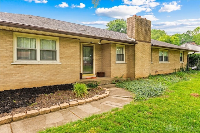 8684 Woodview Dr, Cincinnati, OH 45231 - view of front of house with a chimney, brick siding, a front lawn, and roof with shingles