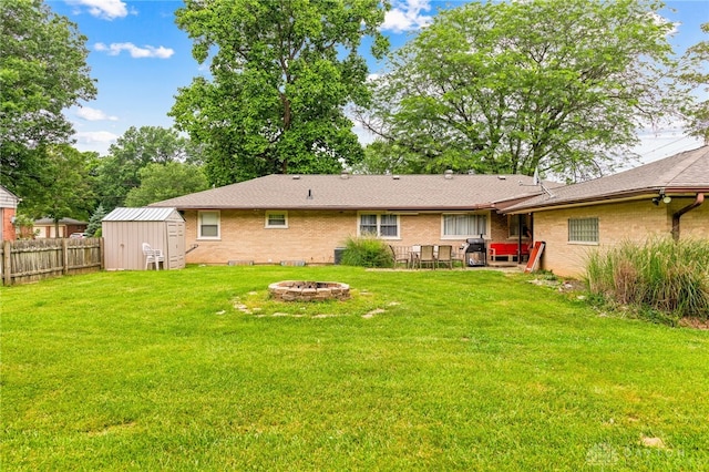 8684 Woodview Dr, Cincinnati, OH 45231 - back of property featuring an outdoor fire pit, a storage shed, brick siding, and a patio