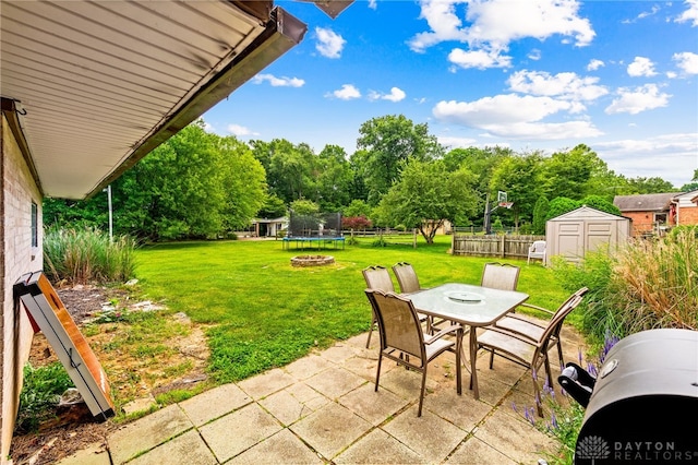 8684 Woodview Dr, Cincinnati, OH 45231 - view of patio / terrace with a trampoline, outdoor dining space, and a shed