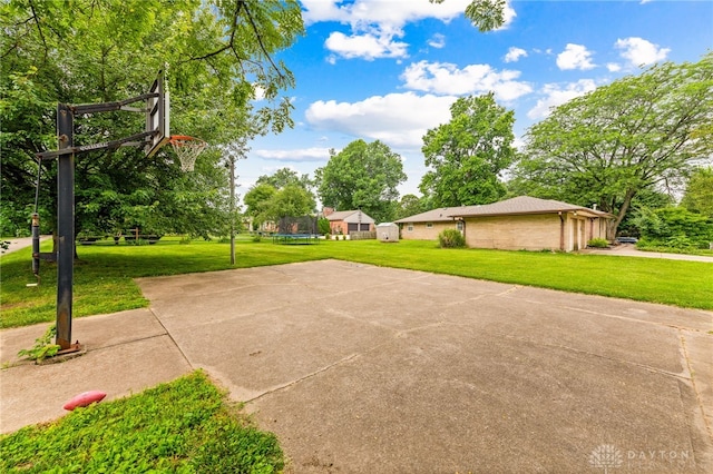 8684 Woodview Dr, Cincinnati, OH 45231 - view of patio featuring a trampoline, basketball court, and view of wooded area