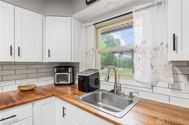 8684 Woodview Dr, Cincinnati, OH 45231 - kitchen featuring wooden counters, decorative backsplash, and white cabinetry