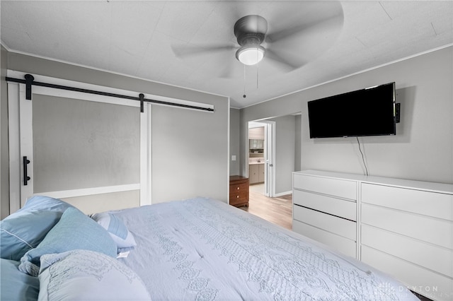 8684 Woodview Dr, Cincinnati, OH 45231 - bedroom with a barn door, wood finished floors, and a ceiling fan