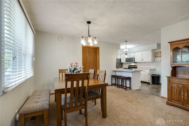 1396 Surrey Rd, Vandalia, OH 45377 - dining space featuring plenty of natural light, light carpet, a textured ceiling, and a chandelier