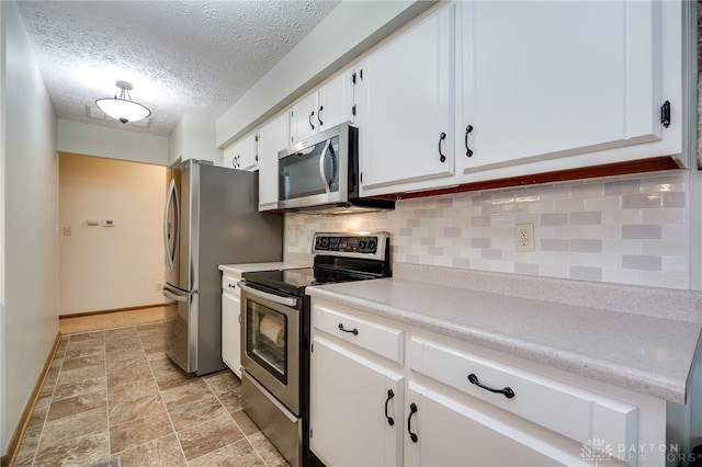 1396 Surrey Rd, Vandalia, OH 45377 - kitchen with stainless steel appliances, white cabinets, tasteful backsplash, light countertops, and stone finish flooring