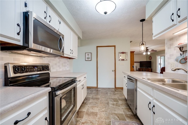 1396 Surrey Rd, Vandalia, OH 45377 - kitchen featuring stainless steel appliances, backsplash, light countertops, white cabinets, and a textured ceiling