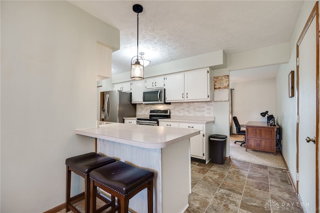 1396 Surrey Rd, Vandalia, OH 45377 - kitchen with appliances with stainless steel finishes, light countertops, a textured ceiling, decorative backsplash, and white cabinetry