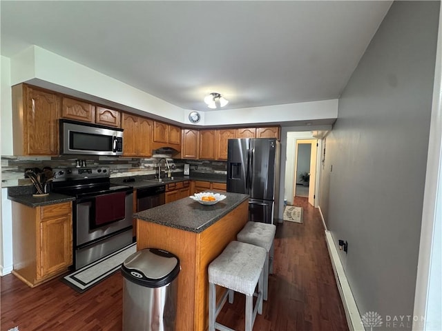 1637 Lammes Ln, New Carlisle, OH 45344 - kitchen featuring stainless steel appliances, decorative backsplash, brown cabinets, and dark countertops