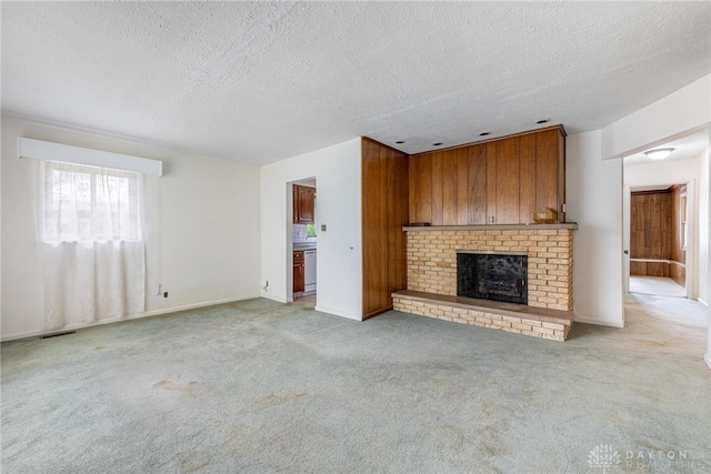 619 Storms Rd, Kettering, OH 45429 - unfurnished living room with light carpet, a brick fireplace, and a textured ceiling