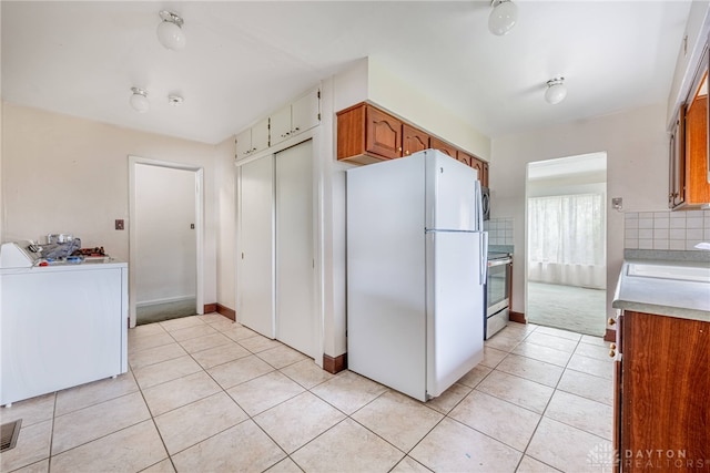 619 Storms Rd, Kettering, OH 45429 - kitchen with freestanding refrigerator, washer / clothes dryer, stainless steel electric stove, light countertops, and light tile patterned floors