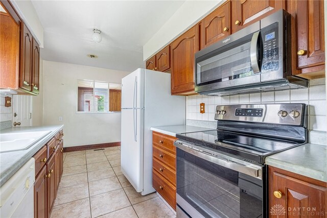 619 Storms Rd, Kettering, OH 45429 - kitchen with appliances with stainless steel finishes, backsplash, and brown cabinetry