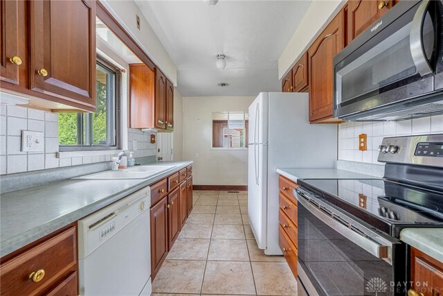 619 Storms Rd, Kettering, OH 45429 - kitchen featuring stainless steel range with electric cooktop, black microwave, white dishwasher, tasteful backsplash, and brown cabinets