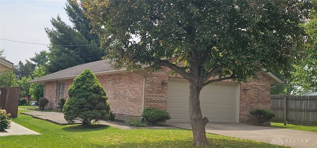 919 N Cherry St, Eaton, OH 45320 - view of side of home with brick siding, an attached garage, and driveway