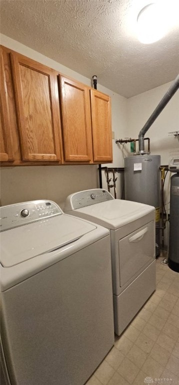 919 N Cherry St, Eaton, OH 45320 - washroom featuring washer and clothes dryer, cabinet space, light floors, water heater, and a textured ceiling