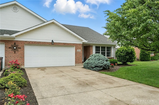 5015 Riverview Ave, Middletown, OH 45042 - traditional-style house with an attached garage, brick siding, driveway, a front lawn, and a shingled roof