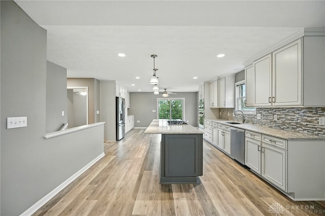 5015 Riverview Ave, Middletown, OH 45042 - kitchen featuring stainless steel appliances, a ceiling fan, backsplash, light wood finished floors, and a center island