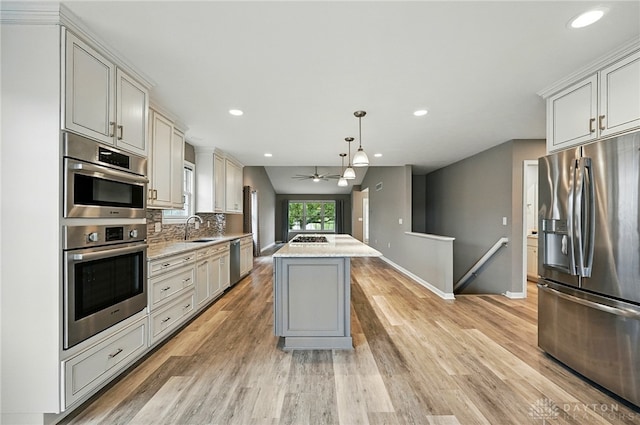 5015 Riverview Ave, Middletown, OH 45042 - kitchen with stainless steel appliances, light wood finished floors, recessed lighting, backsplash, and hanging light fixtures