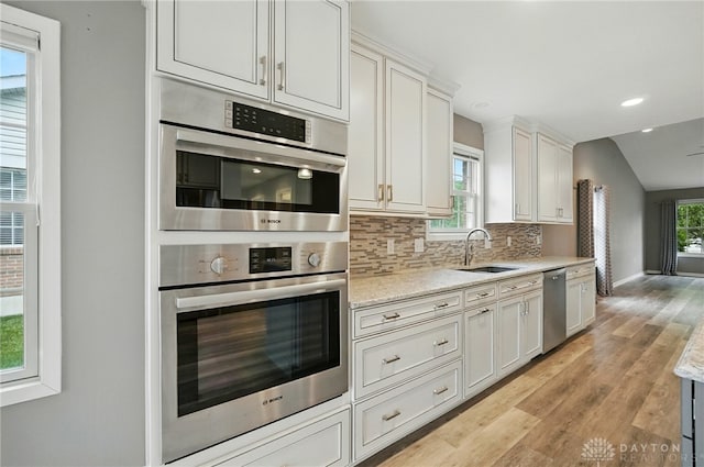 5015 Riverview Ave, Middletown, OH 45042 - kitchen with stainless steel appliances, light wood-style flooring, backsplash, white cabinets, and light stone countertops
