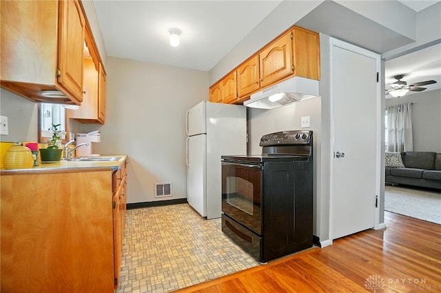 2540 Acorn Dr, Kettering, OH 45419 - kitchen featuring black electric range oven, under cabinet range hood, freestanding refrigerator, ceiling fan, and light countertops