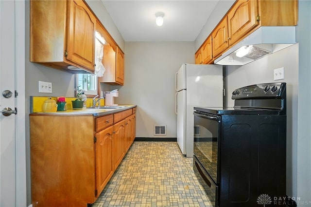 2540 Acorn Dr, Kettering, OH 45419 - kitchen with electric range, under cabinet range hood, light countertops, brown cabinets, and freestanding refrigerator