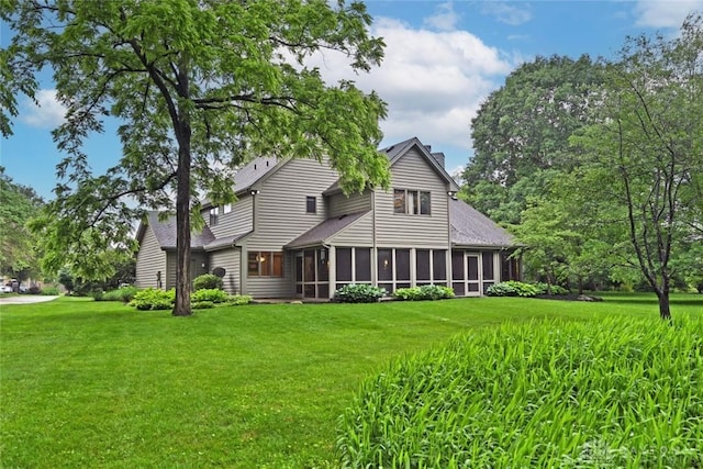 1241 Wind Field Ct, Washington Twp, OH 45458 - back of property with a sunroom, a lawn, a chimney, and roof with shingles