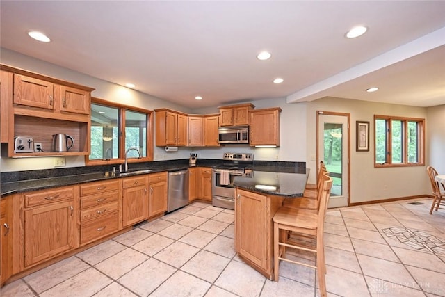 1241 Wind Field Ct, Washington Twp, OH 45458 - kitchen featuring stainless steel appliances, light tile patterned floors, recessed lighting, a kitchen bar, and open shelves