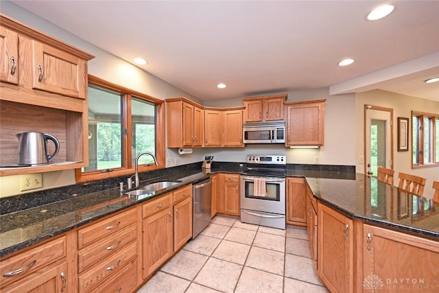1241 Wind Field Ct, Washington Twp, OH 45458 - kitchen with stainless steel appliances, a peninsula, light tile patterned floors, recessed lighting, and dark stone counters