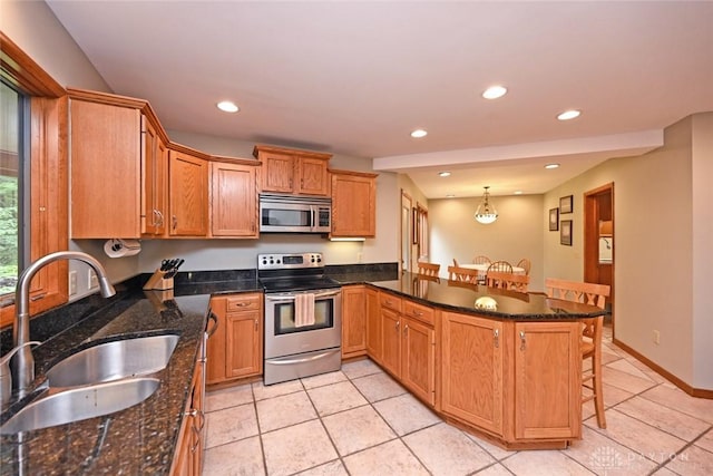1241 Wind Field Ct, Washington Twp, OH 45458 - kitchen featuring stainless steel appliances, a kitchen breakfast bar, recessed lighting, light tile patterned flooring, and a peninsula