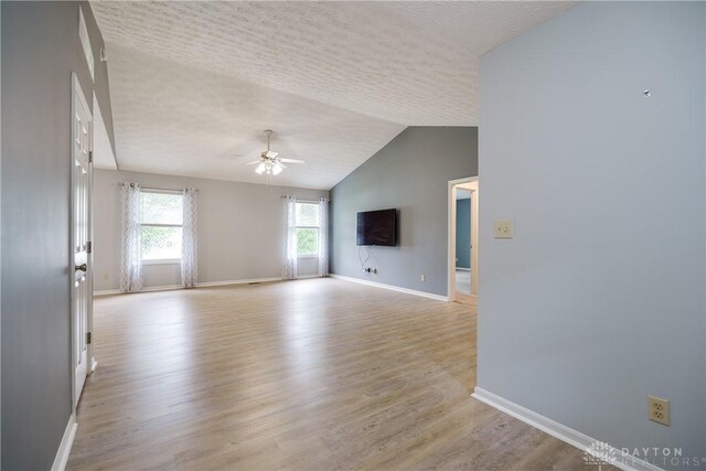 1360 Adamsmoor Dr, Waynesville, OH 45068 - unfurnished living room with a ceiling fan, light wood-style floors, lofted ceiling, and a textured ceiling