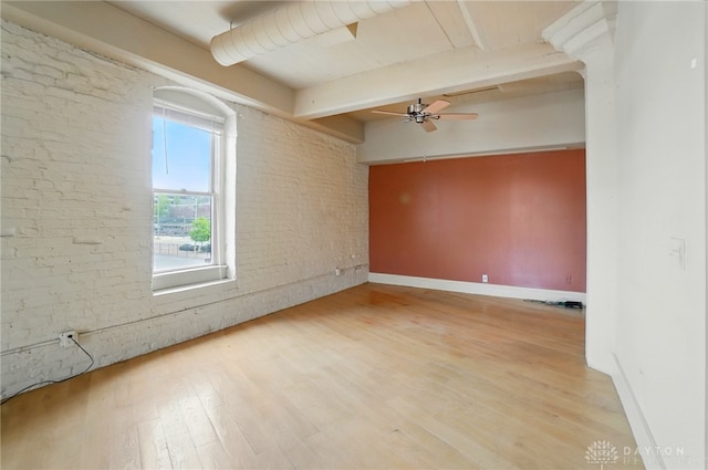 18 S Saint Clair St Unit 203, Dayton, OH 45402 - empty room featuring ceiling fan, beamed ceiling, wood finished floors, and brick wall