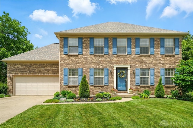 1510 Ash Ridge Ct, Vandalia, OH 45377 - view of front of home featuring an attached garage, concrete driveway, brick siding, a front yard, and a shingled roof