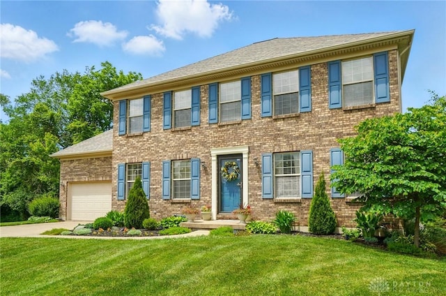 1510 Ash Ridge Ct, Vandalia, OH 45377 - colonial house featuring concrete driveway, a front yard, an attached garage, and brick siding
