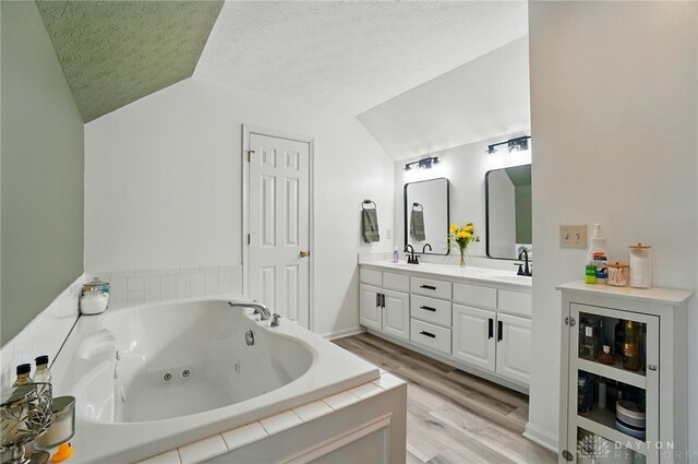 1510 Ash Ridge Ct, Vandalia, OH 45377 - full bathroom with lofted ceiling, double vanity, a textured ceiling, wood finished floors, and a tub with jets