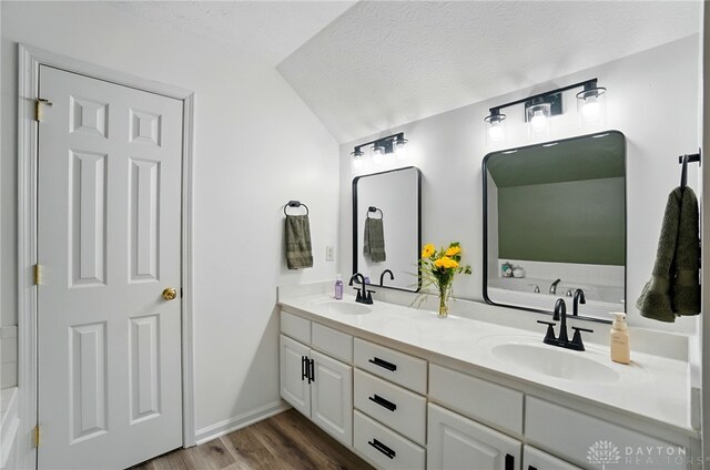 1510 Ash Ridge Ct, Vandalia, OH 45377 - full bath featuring double vanity, wood finished floors, a bath, lofted ceiling, and a textured ceiling