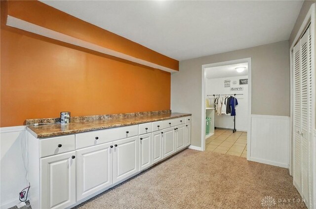 1510 Ash Ridge Ct, Vandalia, OH 45377 - kitchen with white cabinets, light carpet, light tile patterned floors, and a wainscoted wall
