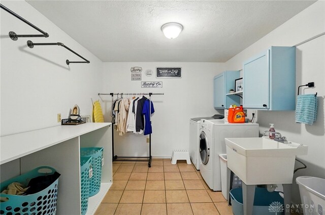 1510 Ash Ridge Ct, Vandalia, OH 45377 - laundry area featuring cabinet space, washing machine and dryer, a textured ceiling, and light tile patterned floors