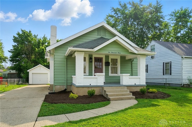 2003 Lowell St, Middletown, OH 45042 - view of front of home featuring covered porch, an outdoor structure, a detached garage, driveway, and a chimney