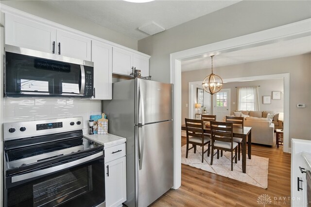2003 Lowell St, Middletown, OH 45042 - kitchen featuring appliances with stainless steel finishes, light countertops, light wood finished floors, and white cabinetry
