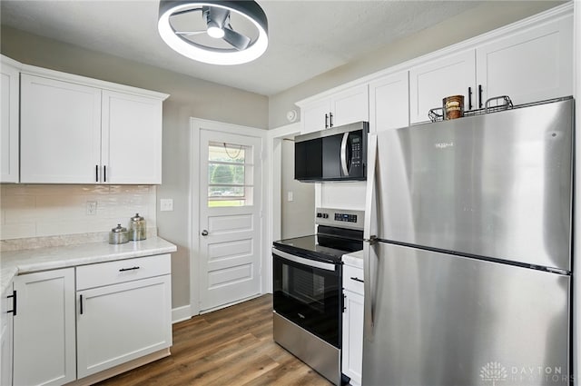 2003 Lowell St, Middletown, OH 45042 - kitchen with appliances with stainless steel finishes, dark wood-style floors, tasteful backsplash, light countertops, and white cabinetry
