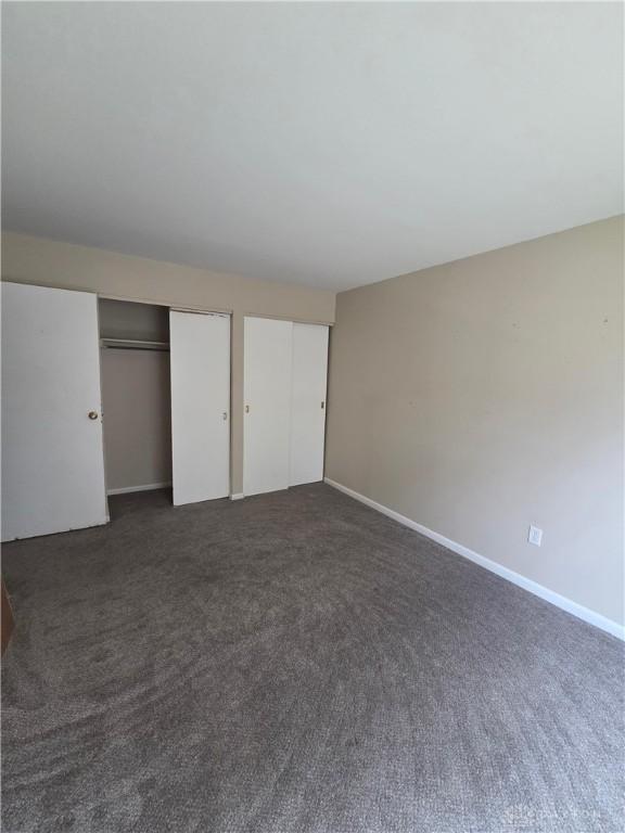 5660 Coach Dr Unit C, Dayton, OH 45440 - unfurnished bedroom with two closets and dark colored carpet