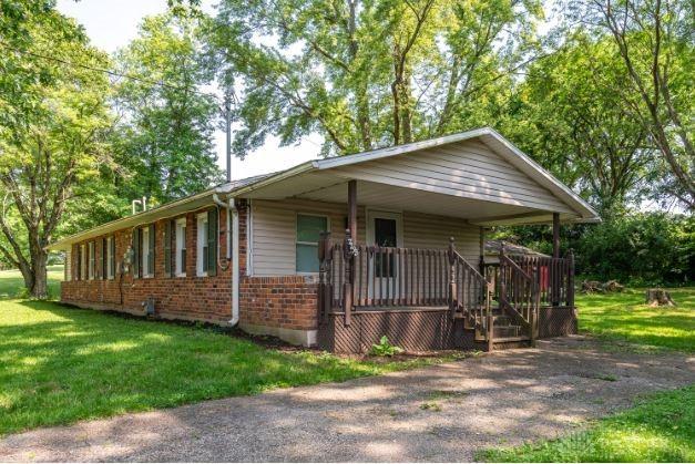 7293 Ellenridge Dr, Franklin, OH 45005 - view of front facade with brick siding, a front yard, and a porch