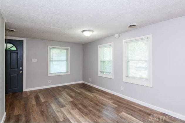 7293 Ellenridge Dr, Franklin, OH 45005 - empty room featuring a textured ceiling and dark wood-style flooring