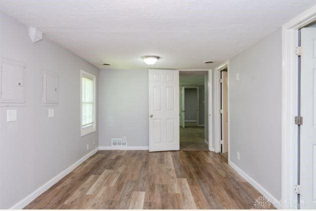 7293 Ellenridge Dr, Franklin, OH 45005 - unfurnished room with a textured ceiling, wood finished floors, and electric panel