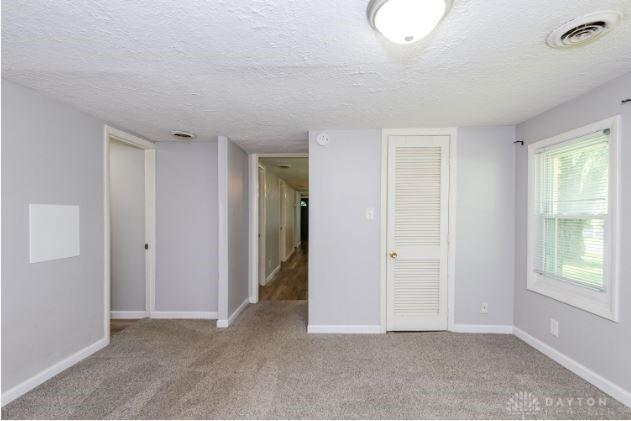 7293 Ellenridge Dr, Franklin, OH 45005 - spare room featuring a textured ceiling and carpet flooring