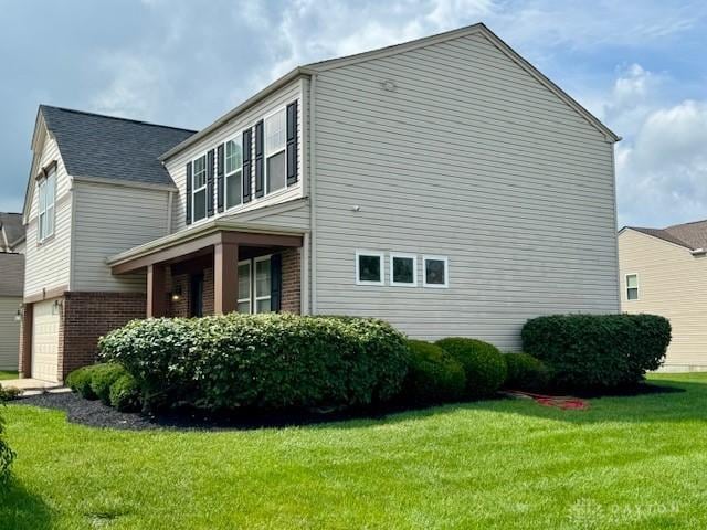 6460 Woodcreek Dr, Middletown, OH 45042 - view of home's exterior with brick siding, a lawn, and a garage