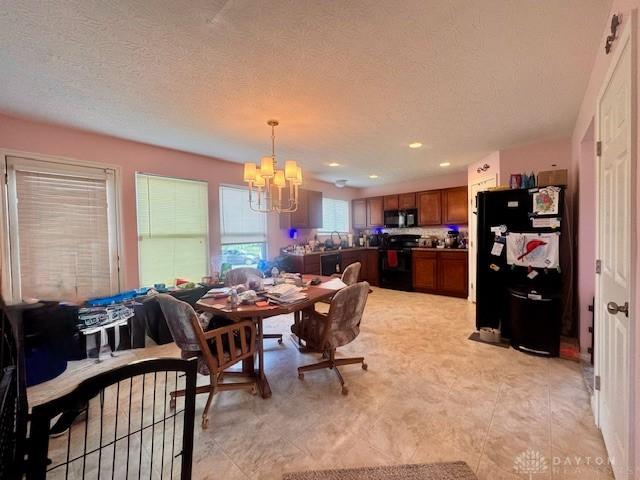6460 Woodcreek Dr, Middletown, OH 45042 - dining space with a chandelier, a textured ceiling, and recessed lighting